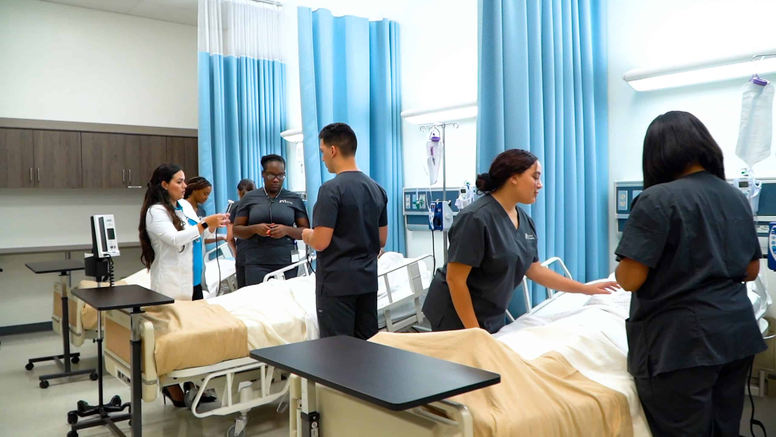 Miramar ASN nursing school students are practicing in an FVI skills lab under the supervision of a member of the nursing faculty