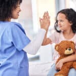 ASN nursing program student working as an RN as a school nurse - nurse high fiving child