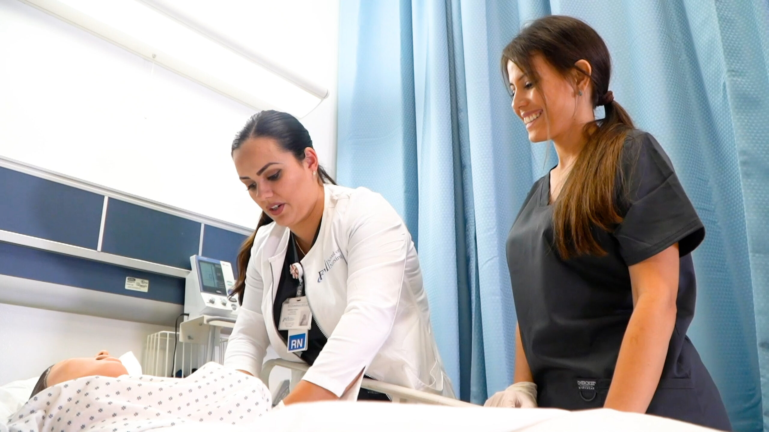 An FVI instructor demonstrates a medical procedure while a miramar ASN nursing program student observes