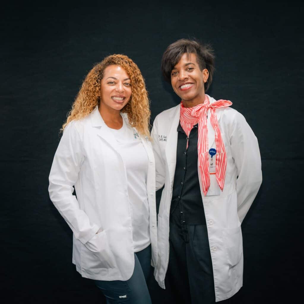 A Miami nursing school student with a member of FVI faculty Dr. Cadogen at a white coat ceremony