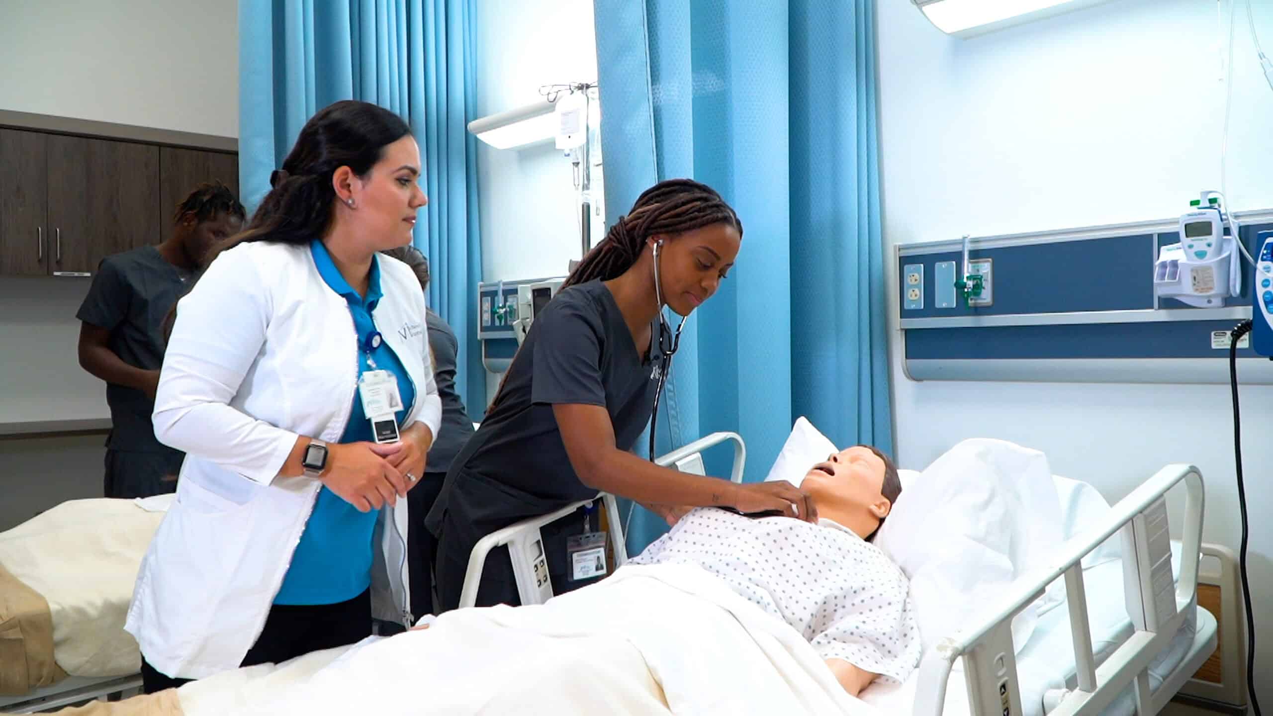 Miami ASN nursing program student and instructor practicing hands on skills with mannequin